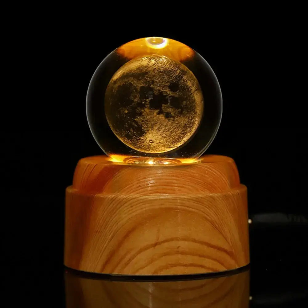 Glowing 3D crystal ball lamp with a detailed moon engraving, illuminated on a wooden base — perfect for ambient lighting and space-themed decor.

