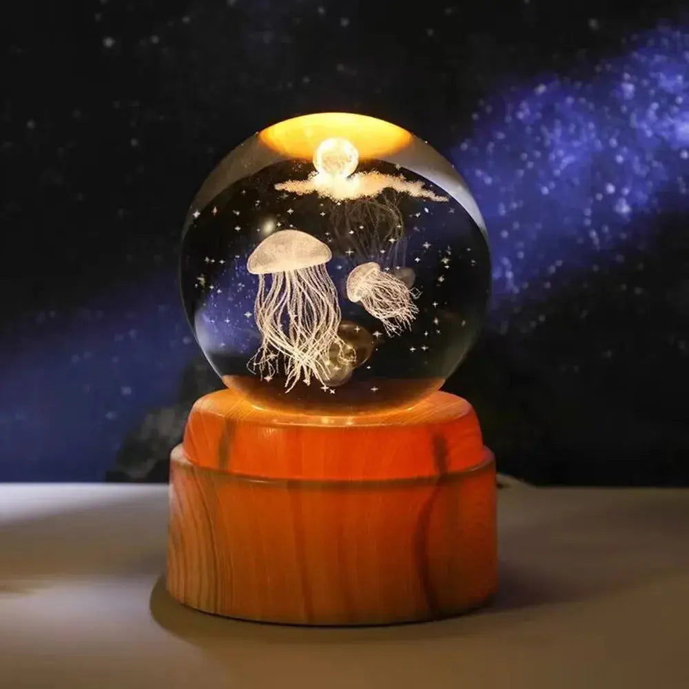  3D LED nightlight with a laser-engraved moon inside a crystal orb, glowing warmly on a wooden base.