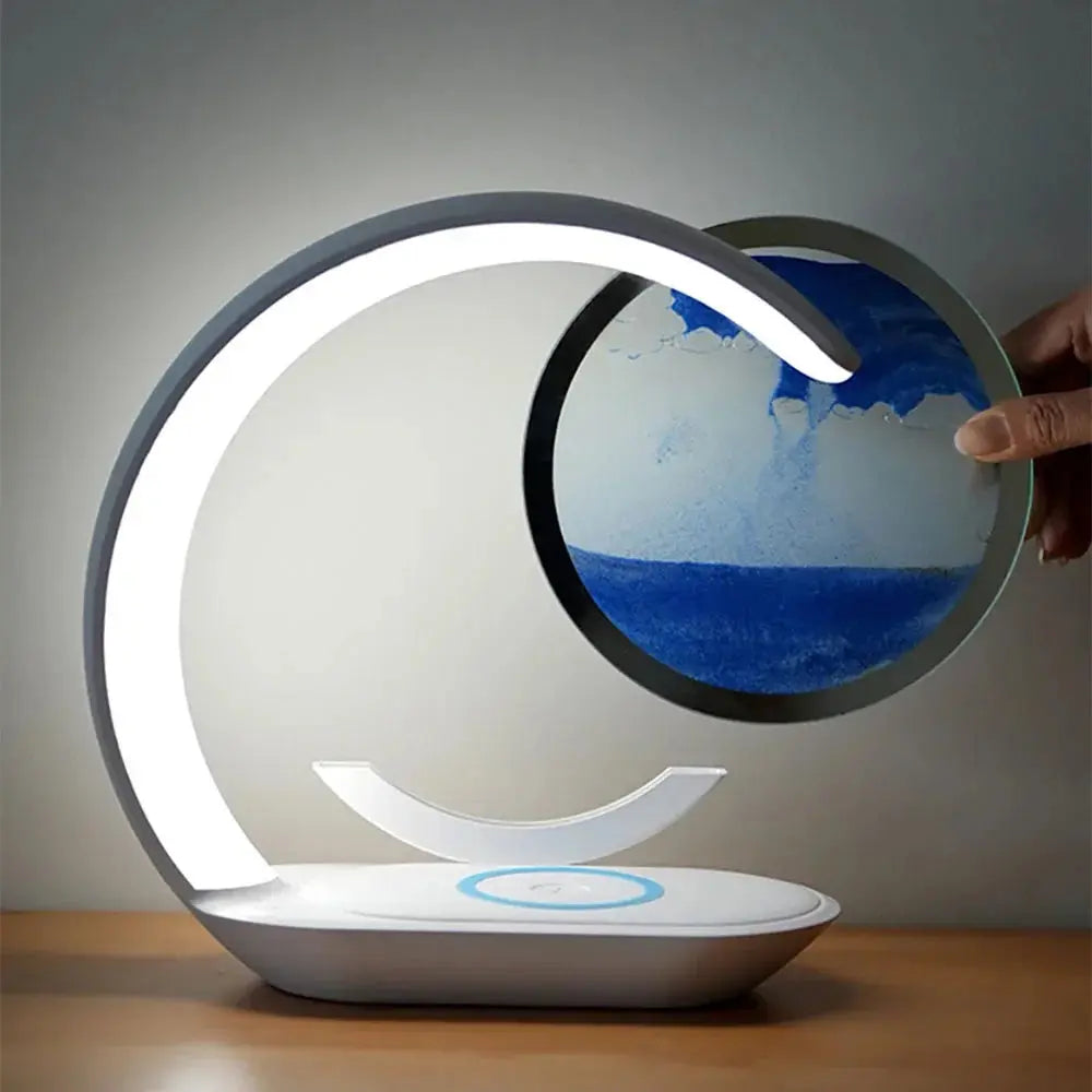 Magnetic LED lamp with an arched design and a floating blue sand timer being placed by a hand.

